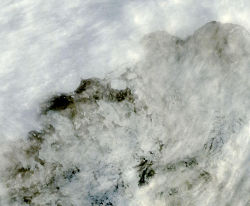Thick cloud cover briefly fell away to reveal this first image of icebergs breaking away from the Sulzberger Ice Shelf due to sea swell from the Tohoku Tsunami, which had originated 8,000 miles away about 18 hours earlier. The icebergs can be seen behind a thin layer of clouds just off the ice shelf near the center of the image. Source: MODIS Rapid Response/NASA.
Click the above image to see the same area 2 days prior