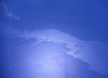 The Gulf oil slick is visible as a bright diagonal swath in this image taken at 28,000 feet from a camera mounted on a B-200 research airplane from NASA's Langley Research Center. Credit: NASA.