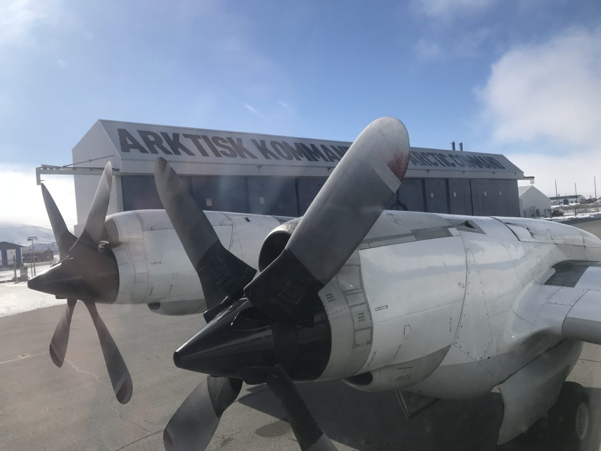 Photo of a P-3 aircraft outside of its hangar in Kangerlussuaq, Greenland, with focus on the airplane's propellers.