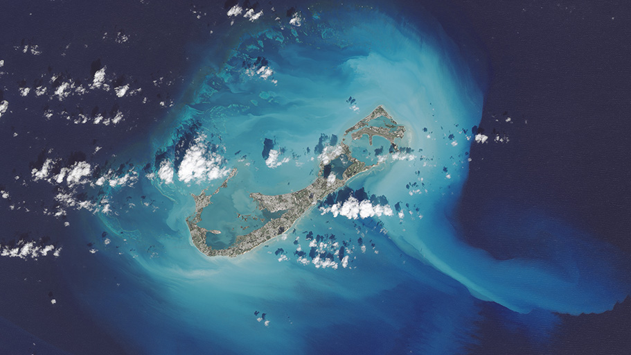 Light blue and white sediment is revealed around islands.