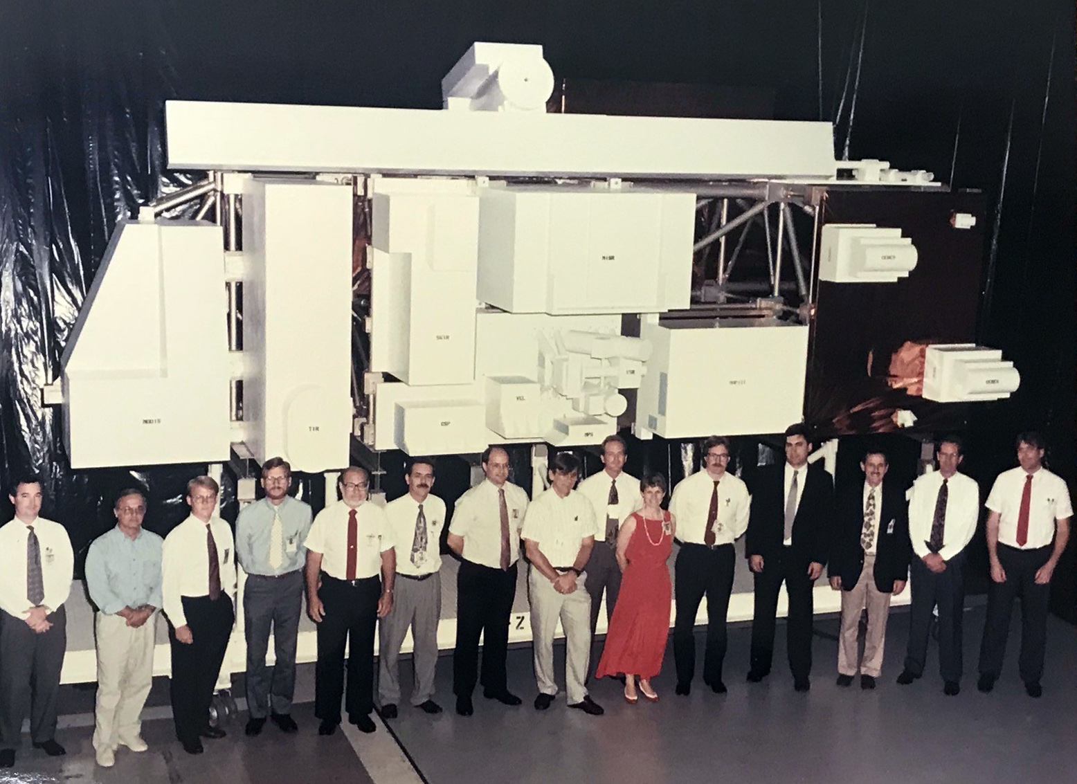 Members of the Terra design team stand in front of a true-to-size model of the satellite in the mid-1990s.