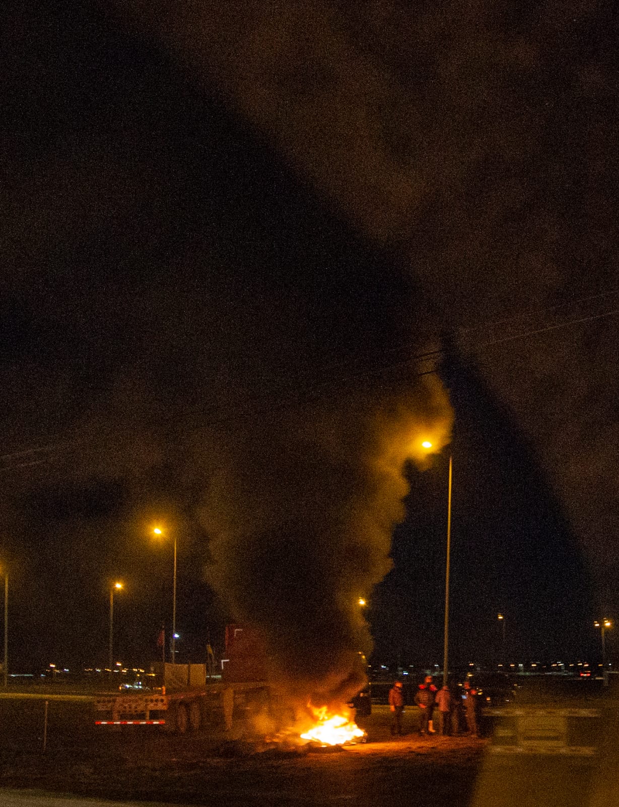 Local Chilean fuel truckers burning tires along the side of the road in protest.
