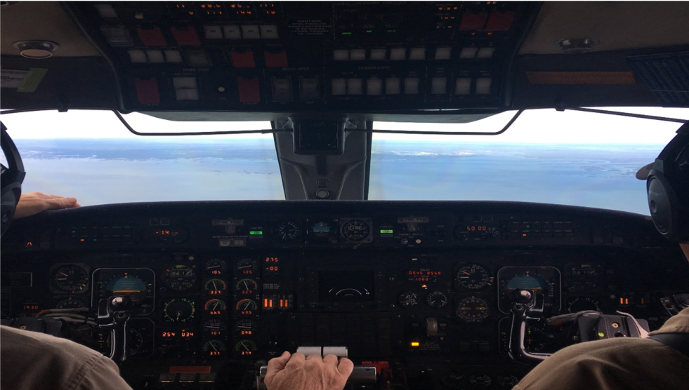 Mandy Bayha gets a pilot's view from the jump seat as the NASA Gulfstream III comes in for landing, the town of Yellowknife on the shores of Great Slave Lake in view.