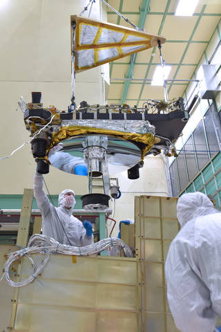 GEDI's Optical Bench (OB) being lowered carefully into the GEDI box structure during integration activities inside the Spacecraft Checkout and Integration Area (SCA) at Goddard Space Flight Center.