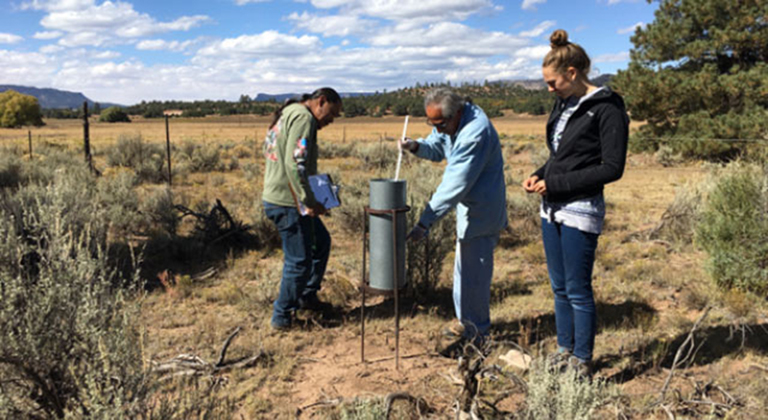 Ralphus Begay and Irving Brady, with the Navajo Nation Department of Water Resources, take monthly precipitation totals at a rain-gauge location.