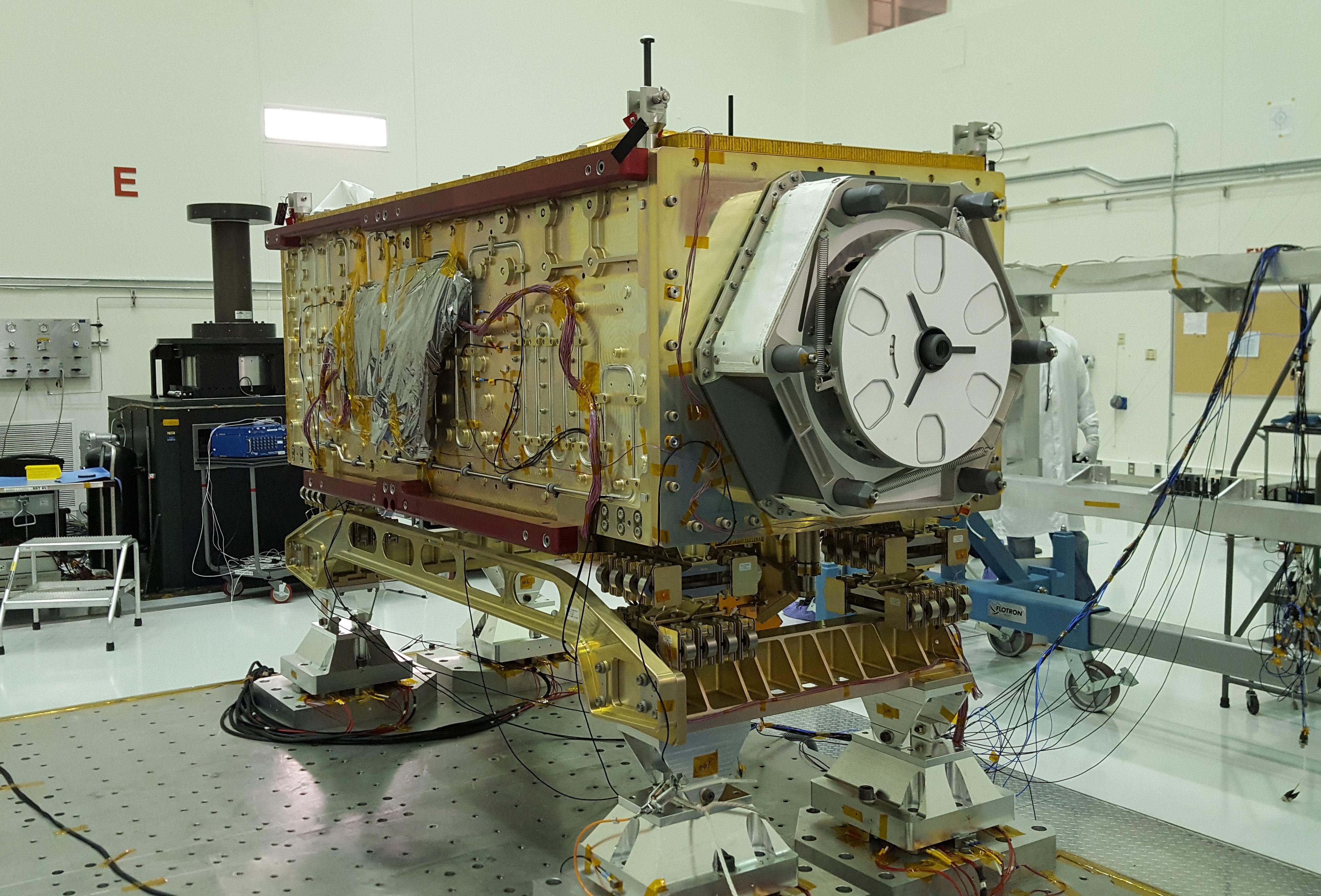 NASA's OCO-3 instrument sits on the large vibration table (known as the "shaker") in the Environmental Test Lab at NASA's Jet Propulsion Laboratory.