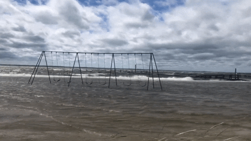 image of swing set getting flooded by ocean water