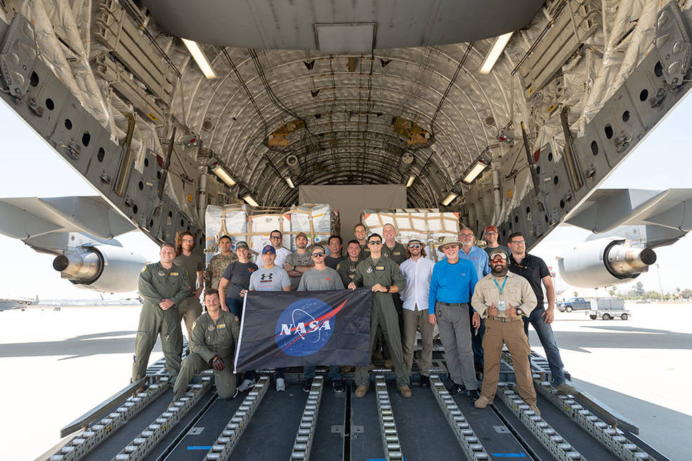 Some of the people who helped to load the hardware for the Surface Water and Ocean Topography (SWOT) satellite's research instruments onto a C-17 airplane pose for a picture. The payload left March Air Reserve Base in Riverside County, California, on June 27 and is headed to France. Credits: NASA/JPL-Caltech