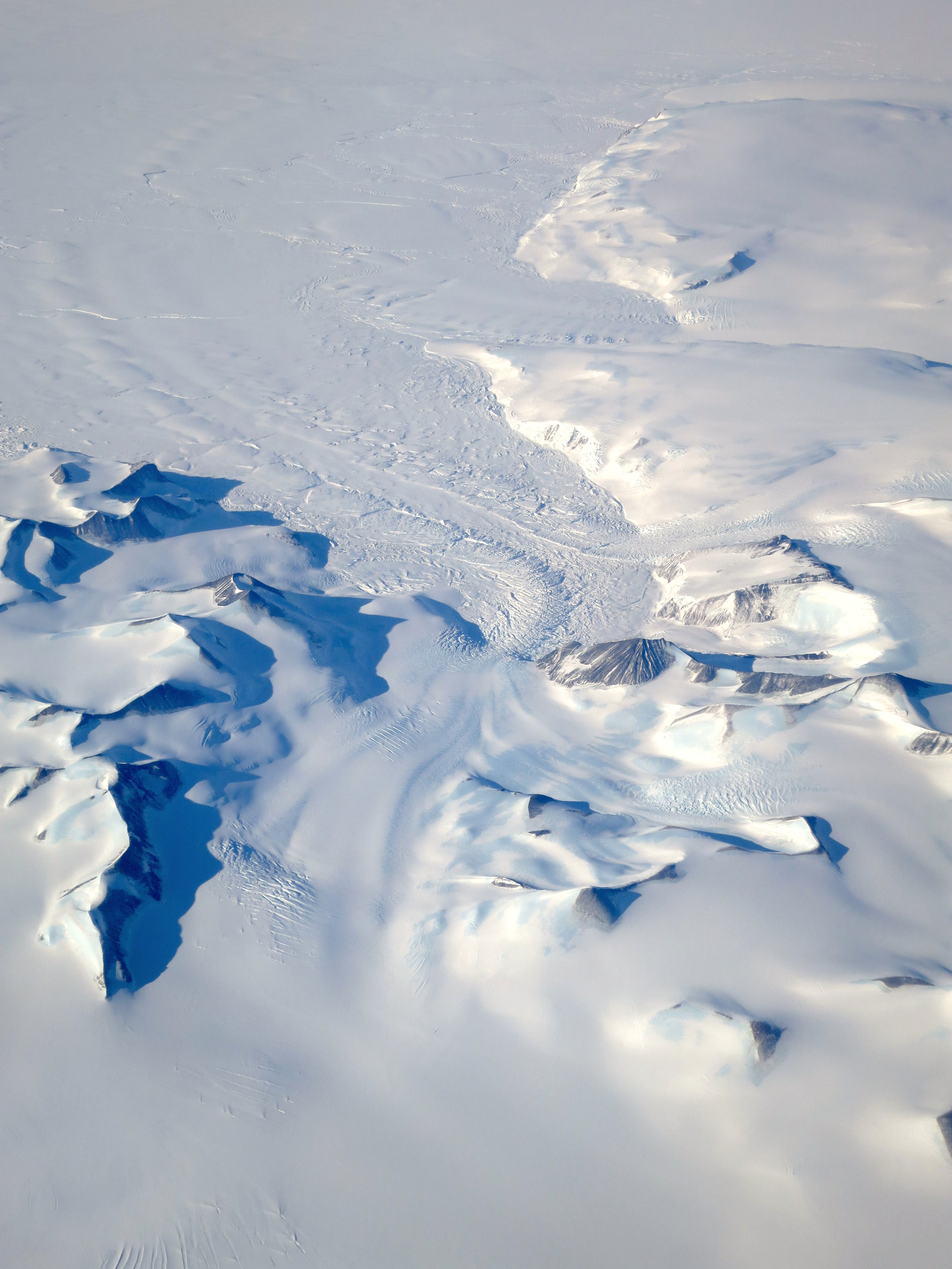 A glacier winds between peaks in the Antarctic Peninsula as seen on Oct. 3, 2015, from the NCAR G-V aircraft during Operation IceBridge's southern campaign. Credit: NASA/David Rabine.
