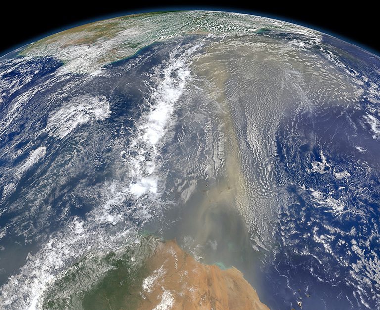 Satellites have documented that human-produced and natural air pollution can travel a long way. This 2014 NASA satellite image shows a long river of dust from western Africa (bottom of image) push across the Atlantic Ocean. Credit: NASA.