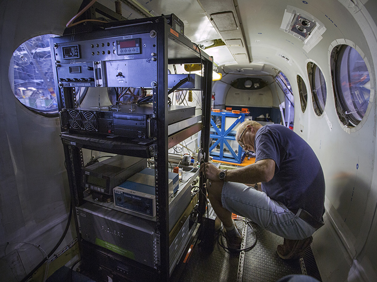 Technician Jim Plant checks an instrument rack aboard the King Air B-200 at NASA's Langley Research Center in Hampton, Virginia, in preparation for the first ACT-America flights this month.
