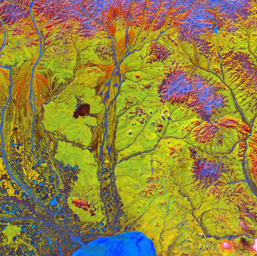 Vivid colors and bizarre shapes come together in this artistic, fantastical image, taken from space on June 15, 2005. The labyrinth of exotic features was spotted along the edge of Russia's Chaunskaya Bay (shown by the vivid blue half circle) in northeastern Siberia. Two major rivers, the Chaun and Palyavaam, flow into the bay, which in turn opens into the Arctic Ocean. Ribbon lakes and bogs are present throughout the area, created by depressions left by receding glaciers.