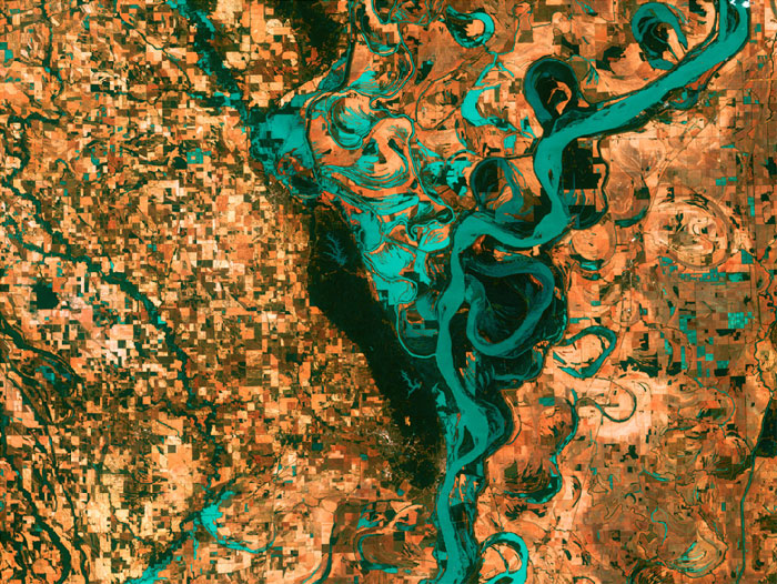 MEANDERING MISSISSIPPI: Small, blocky shapes of towns, fields, and pastures surround the graceful swirls and whorls of the Mississippi River. Countless oxbow lakes and cutoffs accompany the meandering river south of Memphis, Tennessee, on the border between Arkansas and Mississippi, USA. The 'mighty Mississippi' is the largest river system in North America. Image taken by Landsat 7 on May 28, 2003.