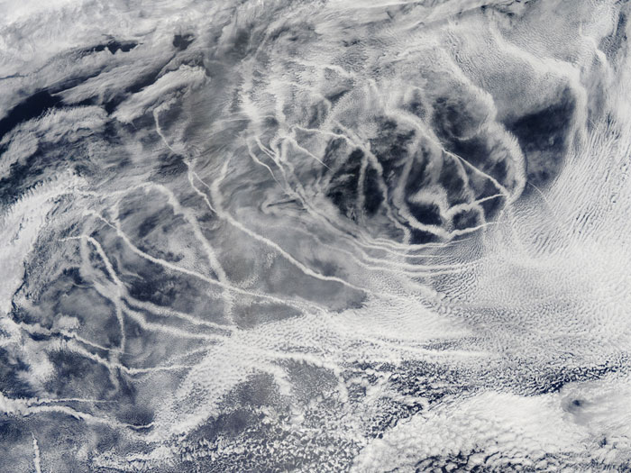 SHIP TRACKS: 'Ship tracks' above the northern Pacific Ocean. These patterns are produced when fine particles from ship exhaust float into a moist layer of atmosphere. The particles seed new clouds or attract water from existing cloud particles. Image taken by the Moderate Resolution Imaging Spectroradiometer (MODIS) onboard NASA’s Aqua satellite on July 3, 2010.
