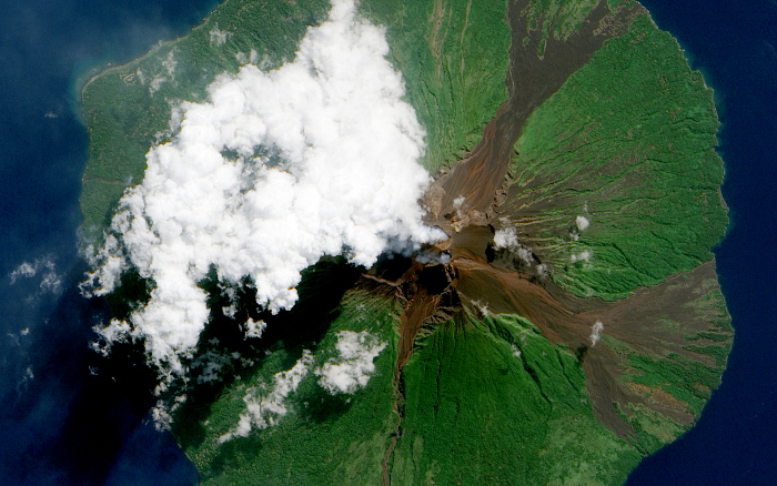 MANAM VOLCANO: Manam Volcano in Papua New Guinea, as seen from space on June 16, 2010. Located 13 kilometers (8 miles) off the coast of mainland Papua New Guinea, Manam forms an island 10 kilometers (6 miles) wide. It is a stratovolcano. The volcano has two summit craters, and although both are active, most historical eruptions have arisen from the southern crater.

On June 16, the volcano released a thin, faint plume as clouds clustered at the volcano's summit. Rivulets of brown rock interrupt the carpet of green vegetation on the volcano’s slopes. White clouds partially obscure the satellite’s view of Manam. The clouds may be the result of water vapor from the volcano, but they may also have formed independently of volcanic activity. The volcanic plume appears as a thin blue-gray veil extending toward the northwest over the Bismarck Sea.