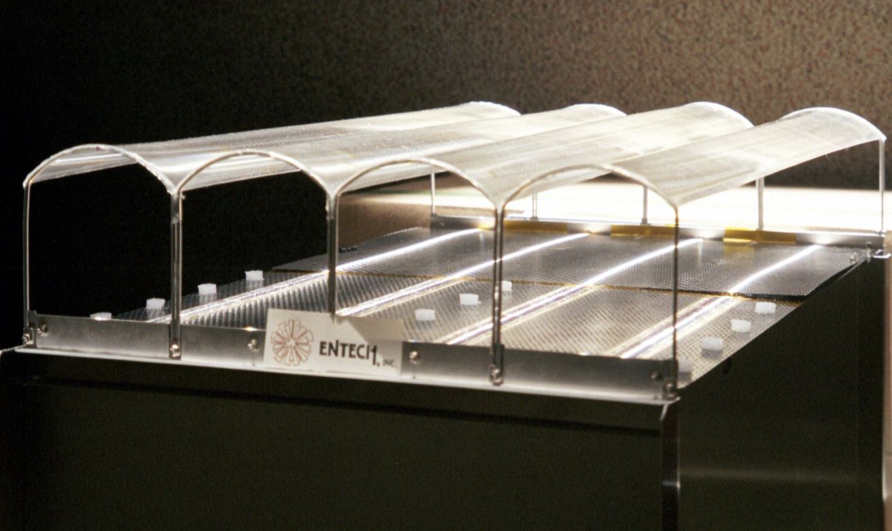 In the Stretched Lens Array, a descendant of SCARLET, a thin film studded with tiny prisms is stretched between arches to help it focus sunlight onto solar cells below. 