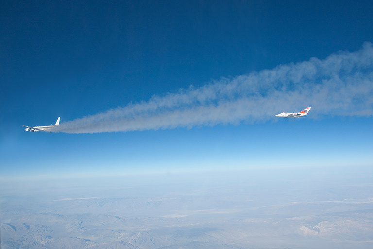A research plane samples exhaust from NASA’s DC-8 to compare emissions from standard jet fuel with those from a biofuel blend.