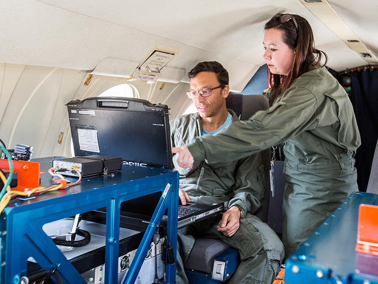 NASA Goddard's Peter Pantina, left, and Langley's Laura Judd make final checks before a flight.