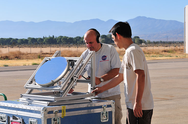Principal Investigator Haris Riris (left) and Stewart Wu prepare a prototype of the methane sounder (the mirror is an alignment tool) before demonstrating it aboard NASA’s DC-8 research aircraft in 2011. Another flight is scheduled for later this year. Credit: Emily Schaller. View a larger image.