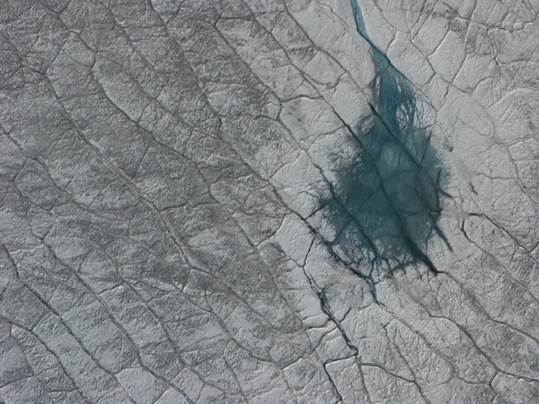 A grayish turquoise melt pond on the Greenland ice sheet, as seen from the air. Credit: NASA