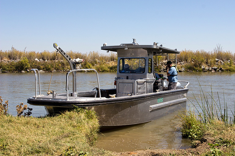 The USGS R/V Mary Landsteiner shown at a brief stop during a study in the Northern San Francisco estuary. USGS scientist Bryan Downing is shown calibrating the on-board real-time underway measurement system. Credit: Stephen de Ropp, de Ropp Media.