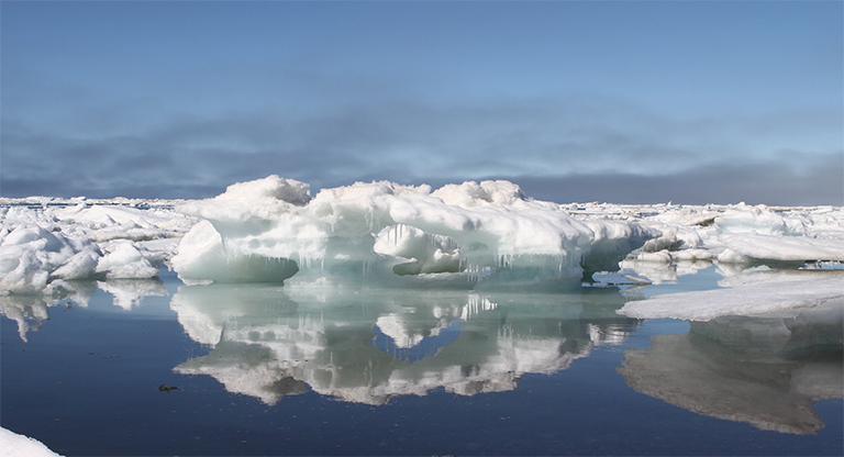 Photo of arches of melting ice over the ocean.