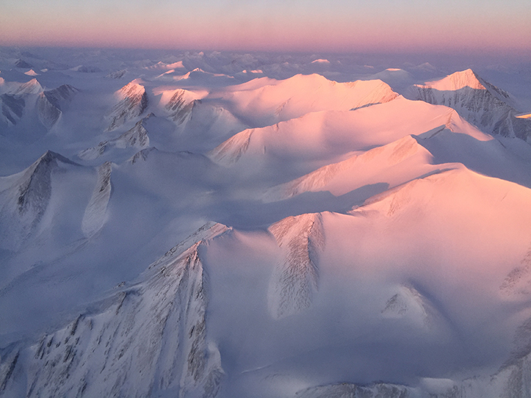 Ellesmere Island mountain tops bathed in light as the sun began to peak over the horizon during Operation IceBridge’s first flight of its 2017 Arctic campaign, on March 9, 2017. Credit: NASA/Nathan Kurtz.