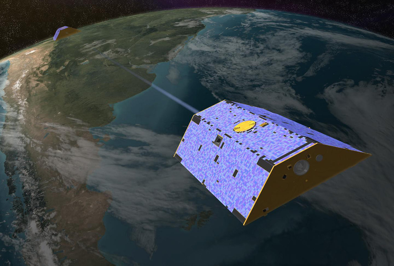 An artist's rendering of the twin GRACE satellites in orbit over Earth.