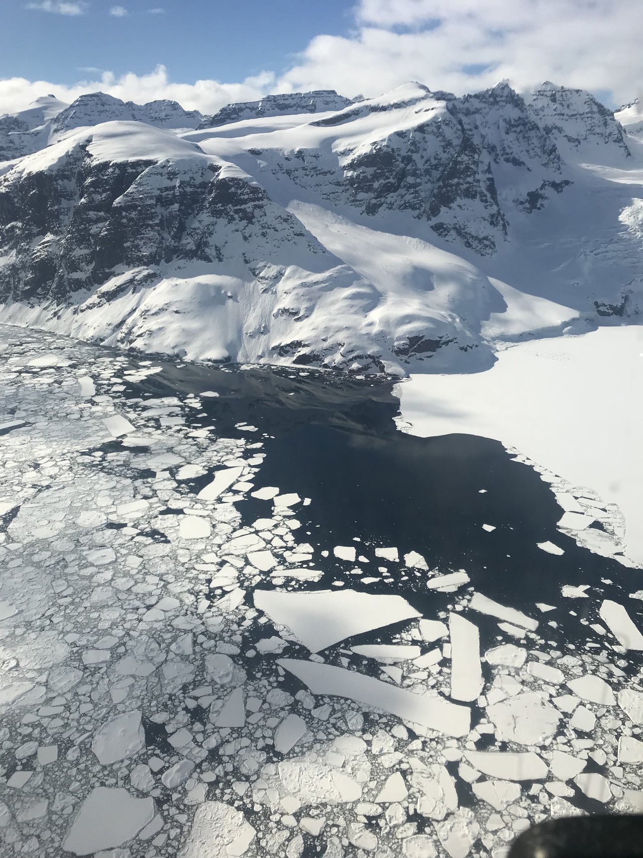 Above Greenland, where land ice meets sea ice and some open water. Credit: NASA/Linette Boisvert