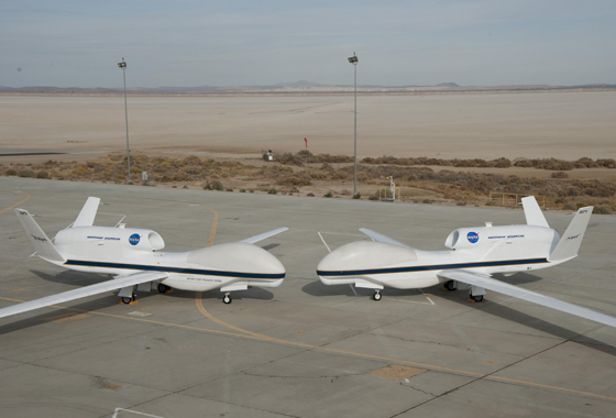 Their bulbous noses almost touching, NASA's two Global Hawks lined up nose-to-nose on the ramp at NASA's Dryden Flight Research Center on Edwards Air Force Base. Bearing NASA tail numbers 871 and 872, the two autonomously operated unmanned aircraft will be flown during the coming multi-year HS3 hurricane study. Credit: NASA / Tony Landis
